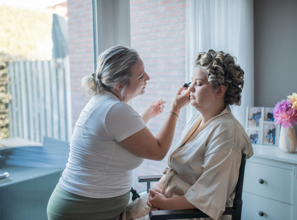 Bruid wordt klaargemaakt door de make-upartist. Trouwfotograaf Puur Geluk Fotografie legt de bruiloft vast. || Trouwfotograaf || Trouwfotograaf in Zeeland