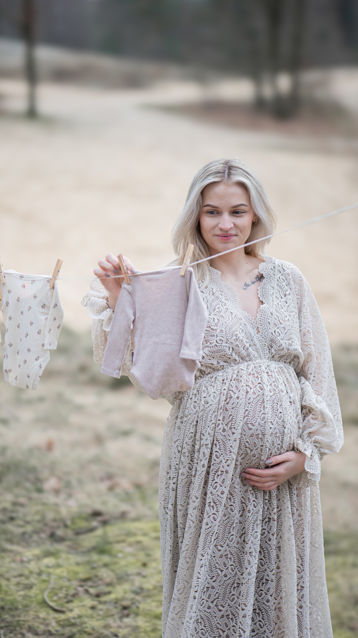 Puur Geluk Fotografie legt een verhalend zwangerschapsmoment vast in de natuur, waar een aanstaande moeder babykleertjes ophangt, rustig en natuurlijk gefotografeerd met aandacht voor verwachting en verbinding.