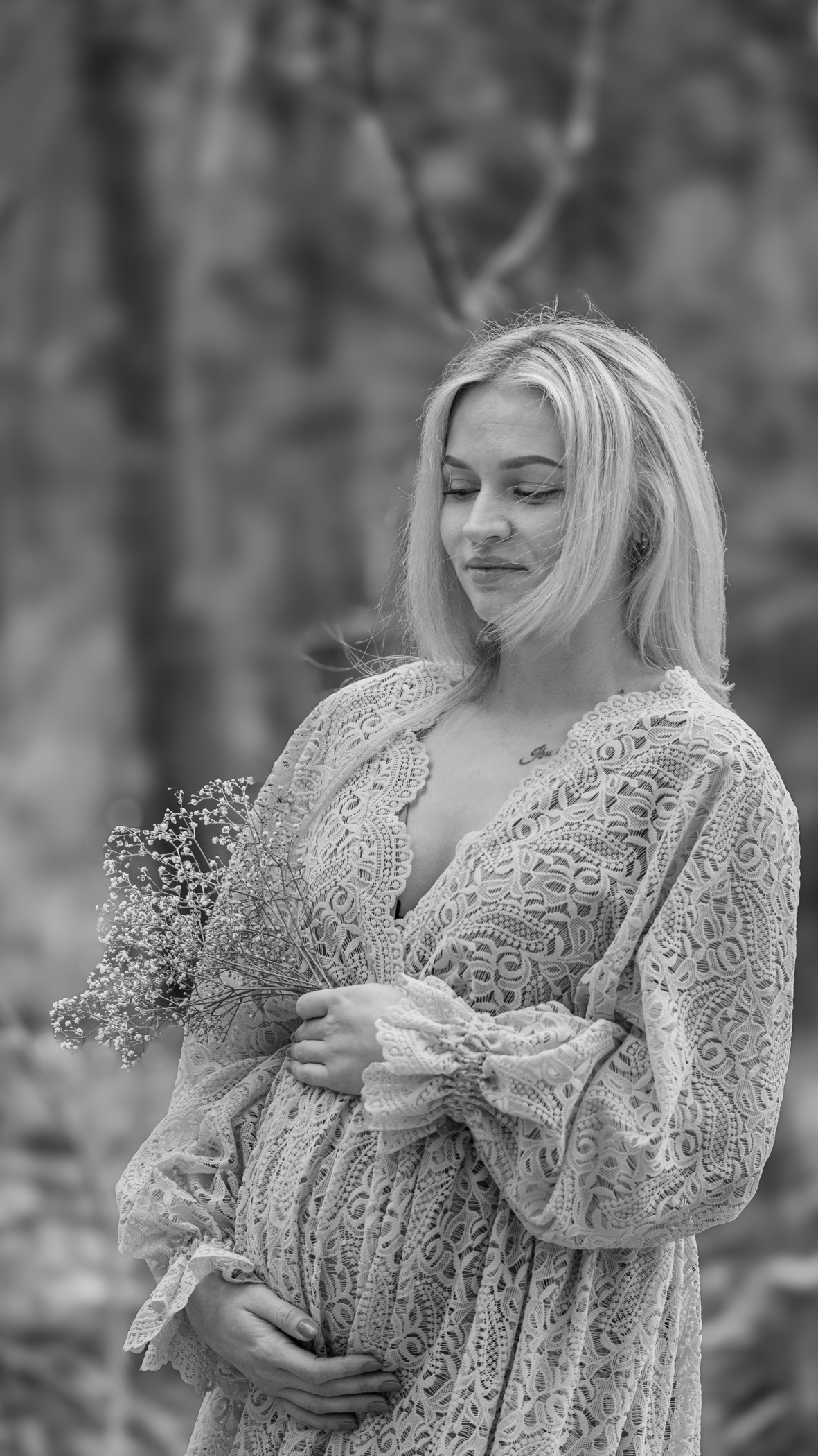 Puur Geluk Fotografie legt een tijdloos zwangerschapsportret vast in zwart-wit, waar een aanstaande moeder in de natuur rustig haar buik vasthoudt, puur en met aandacht voor verwachting gefotografeerd.